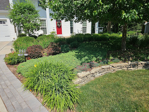 Front entry landscape bed with layered greenery and stone edging